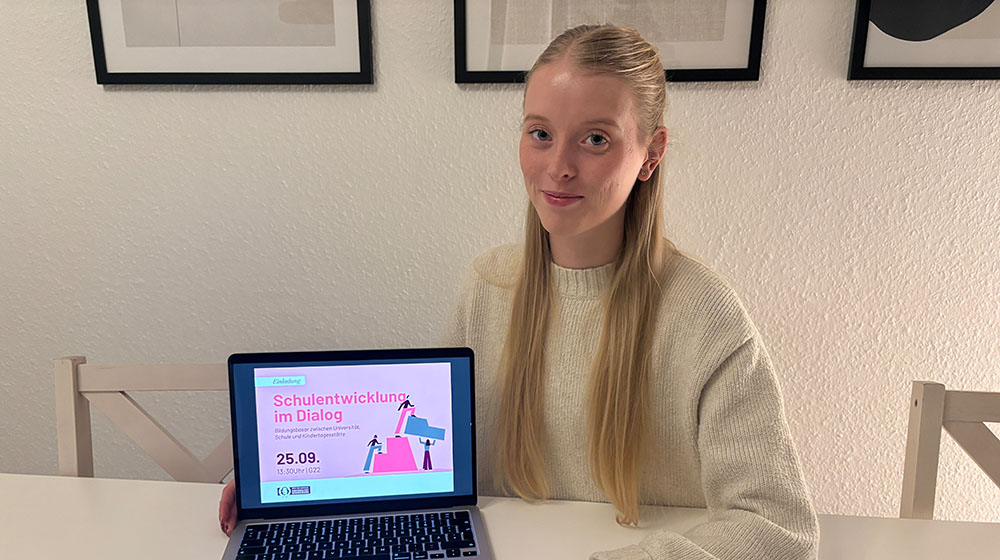 Leoni Schramm zeigt Plakat zur Veranstaltung 
