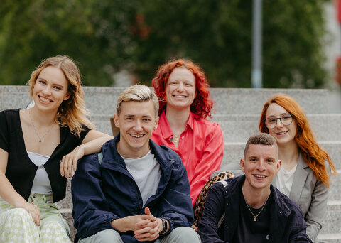 Studierende sitzen auf einer Treppe auf dem Campus (Jana Dünnhaupt/ Uni Magdeburg)